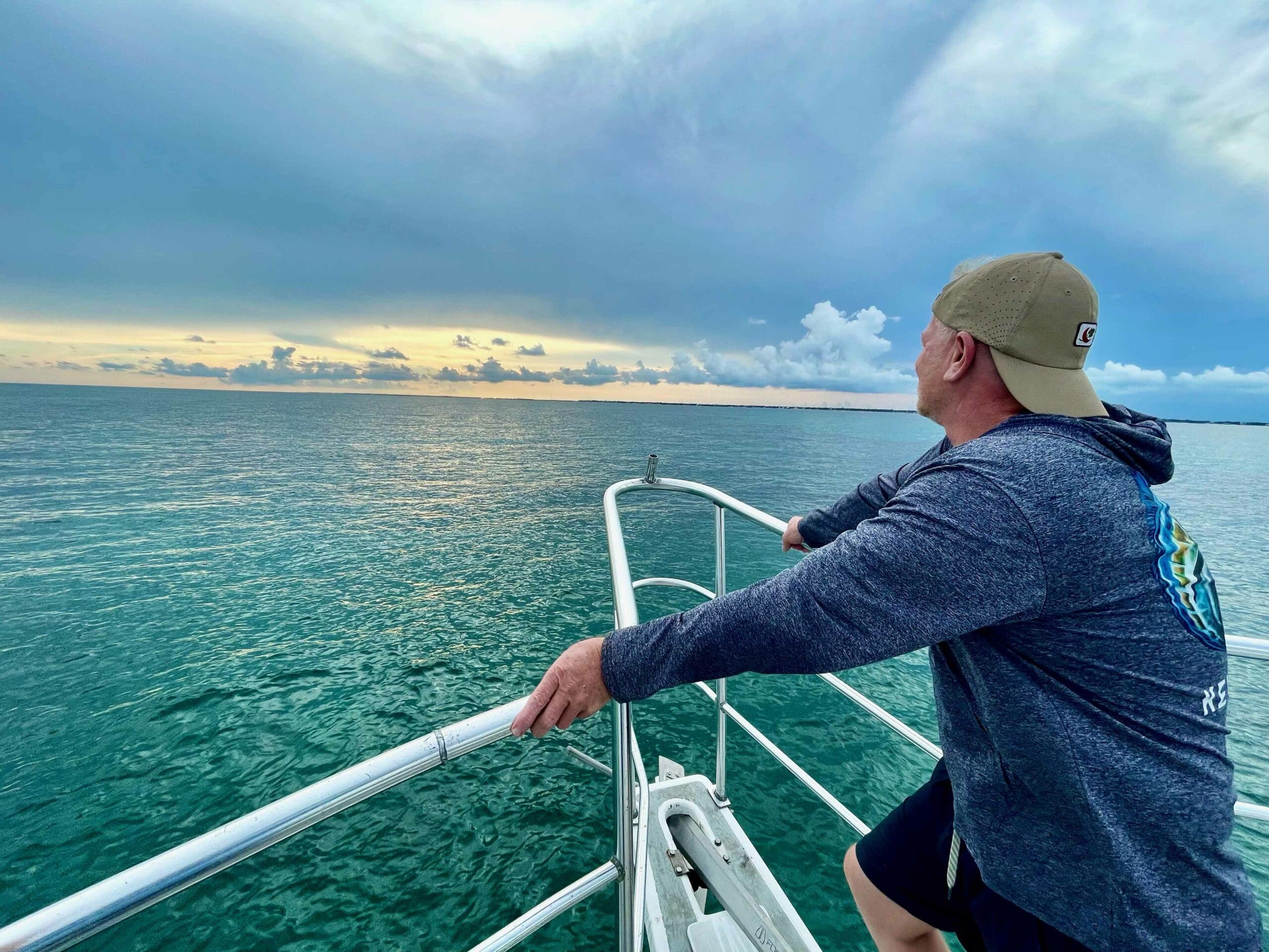 Man looking out on ocean sunset