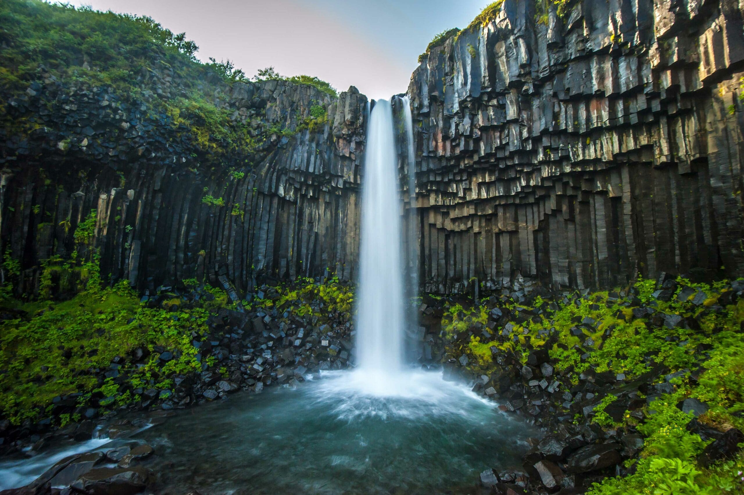 Green waterfall over rocks