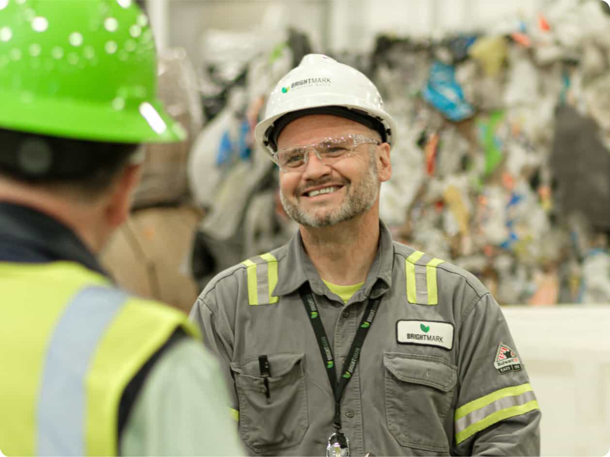 Brightmark worker in a hard hat having a conversation with another worker.