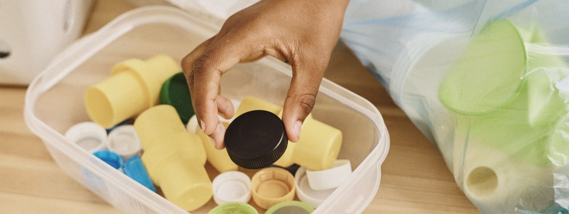 A hand sorting plastic caps