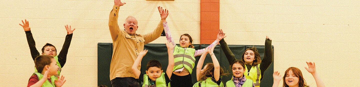 Kids jumping in the air inside a gymnasium