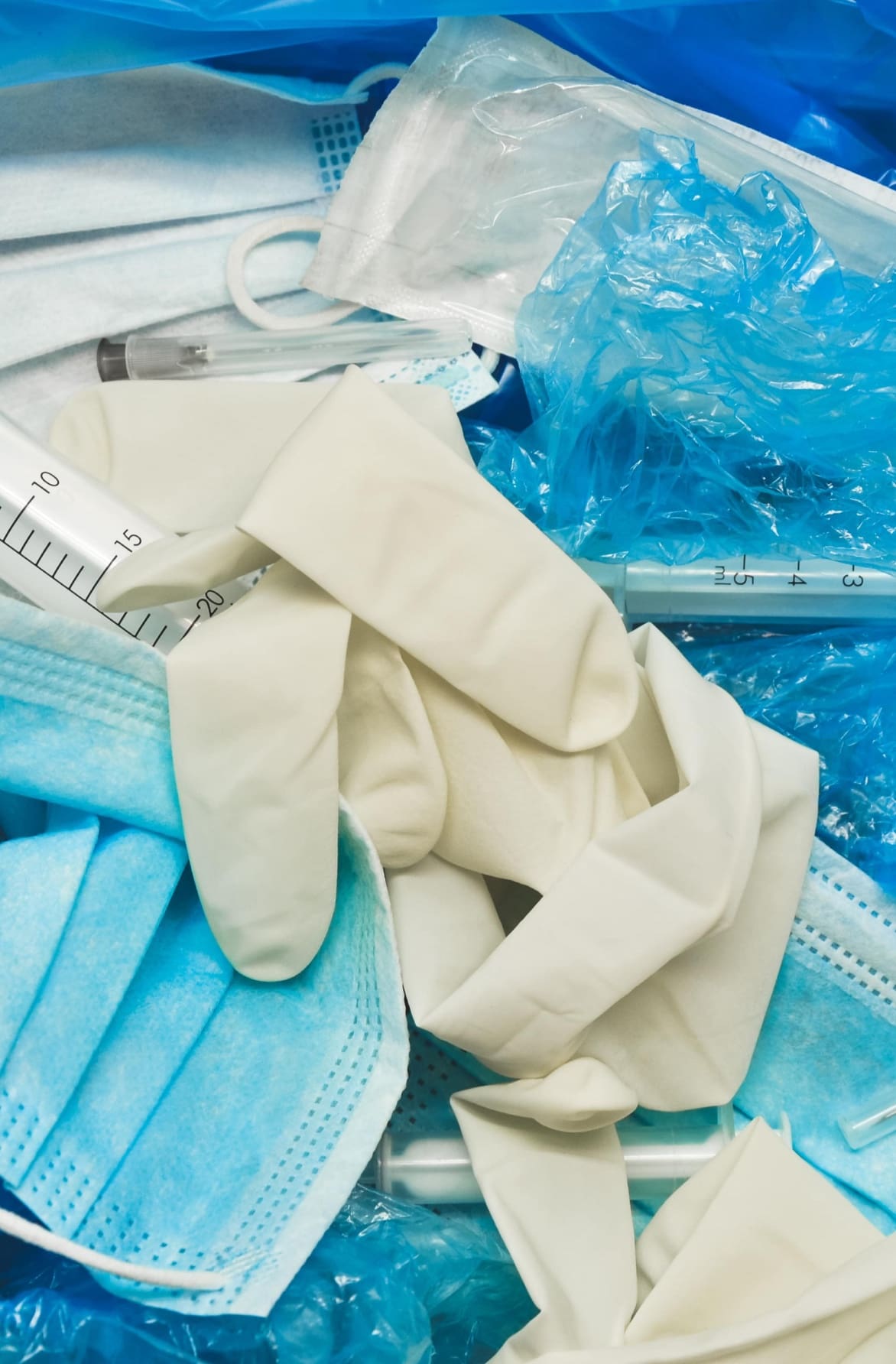 Closeup of medical plastic gloves and face masks in the garbage