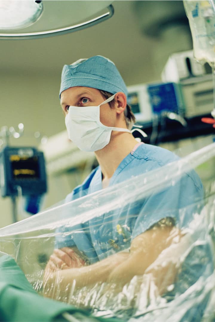 Surgeon sitting near plastic sanitation sheets