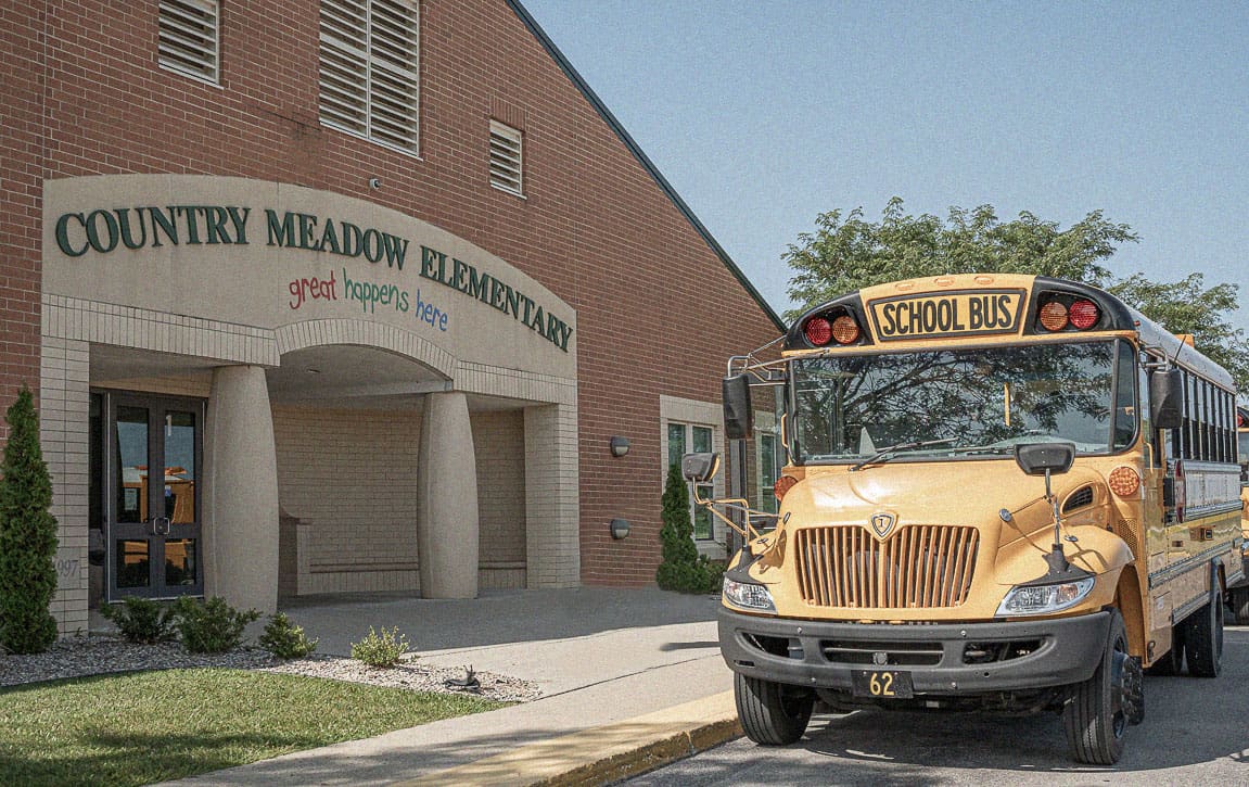 Yellow school buses in front of a school building