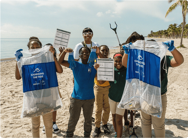 Group of students showing their beach cleanup bags